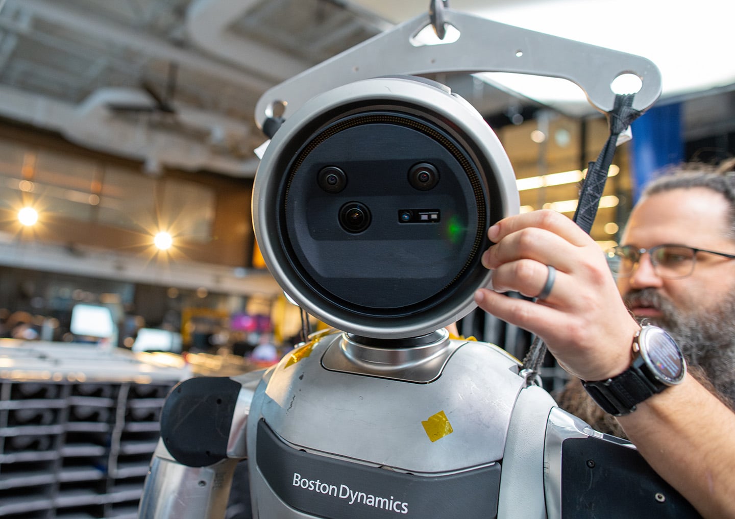 a close up on Atlas's head while an engineer works on the robot